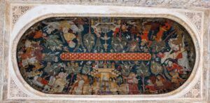 Un fresc detallat en un sostre oval representa una escena elaborada amb nombroses figures, cavalls i estructures. Lobra dart està emmarcada per detalls arquitectònics ornamentats, que mostren colors vius i patrons complexos.