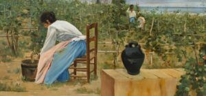 Una dona amb una brusa blanca i una faldilla de colors sasseu en una cadira en una vinya, cuidant una cistella. Una gerra negra descansa sobre una superfície de fusta propera. Es veuen dues figures treballant entre les vinyes al fons.